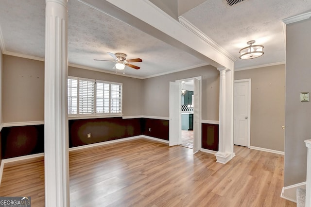 unfurnished room with a textured ceiling, ornamental molding, ceiling fan, and light wood-type flooring