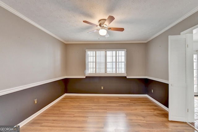 empty room with a textured ceiling, ceiling fan, ornamental molding, and light hardwood / wood-style flooring