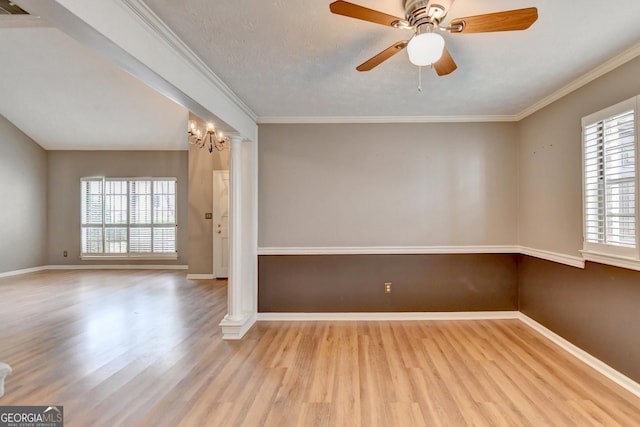 empty room with ornate columns, ornamental molding, a textured ceiling, light hardwood / wood-style flooring, and ceiling fan with notable chandelier