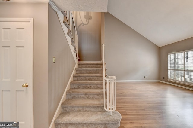 stairway with lofted ceiling and wood-type flooring