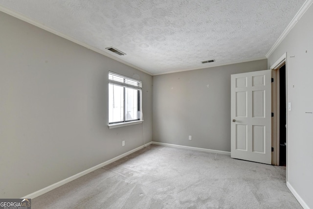 carpeted empty room featuring a textured ceiling and crown molding