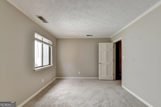 carpeted spare room with a textured ceiling and crown molding