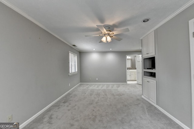 unfurnished living room with ceiling fan, ornamental molding, and light colored carpet