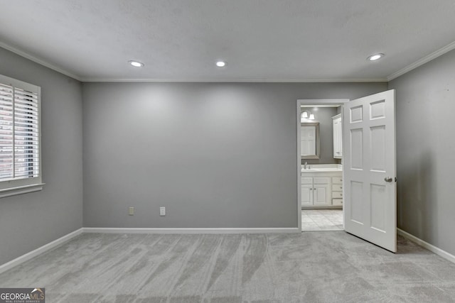 unfurnished bedroom featuring connected bathroom, crown molding, and light colored carpet