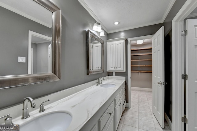 bathroom featuring a textured ceiling, ornamental molding, tile patterned floors, and vanity