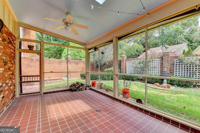 unfurnished sunroom featuring ceiling fan and a skylight