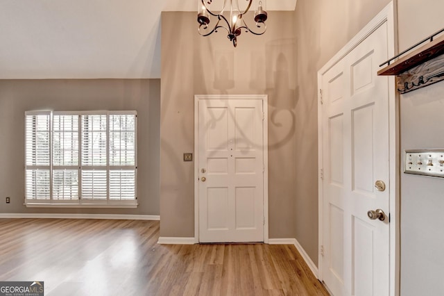 entrance foyer with a chandelier, light hardwood / wood-style flooring, and a wealth of natural light