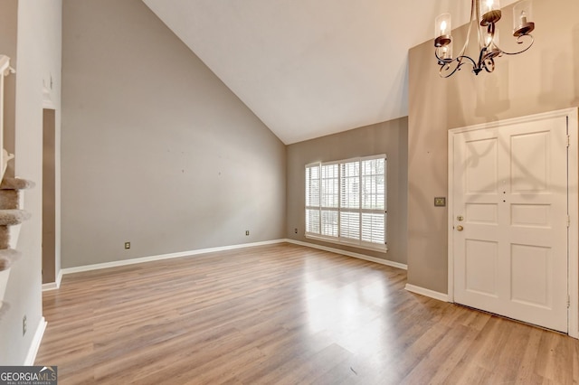 entryway featuring light hardwood / wood-style floors, an inviting chandelier, and high vaulted ceiling