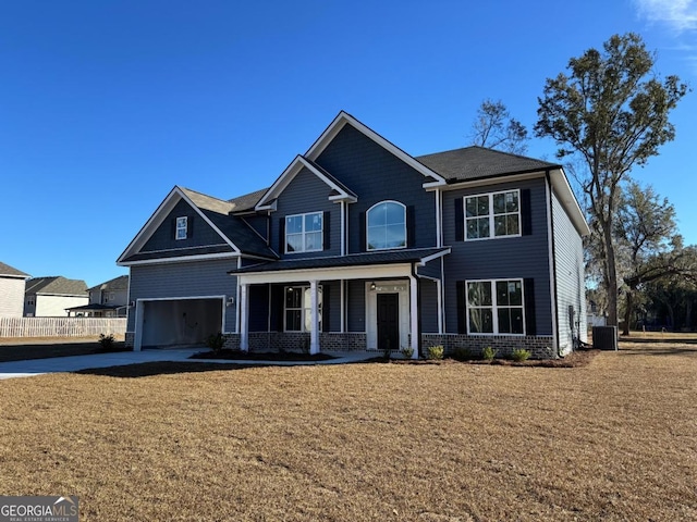 view of front facade featuring a garage, central air condition unit, and a front lawn