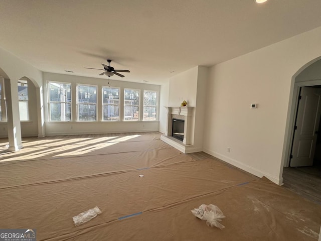 unfurnished living room with ceiling fan and a wealth of natural light