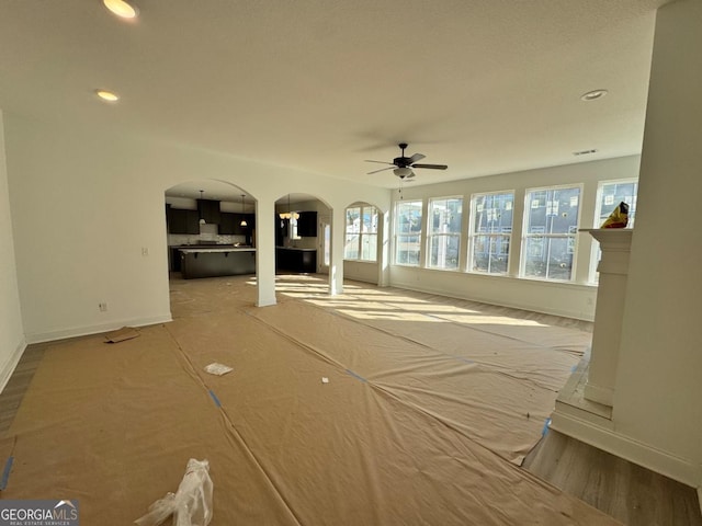 unfurnished living room featuring ceiling fan