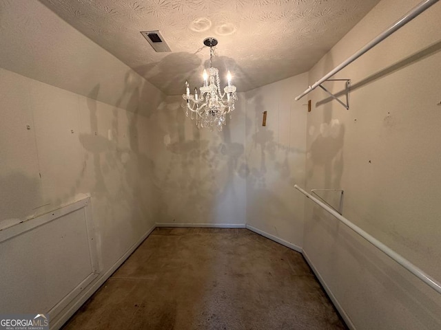 walk in closet featuring lofted ceiling and a chandelier