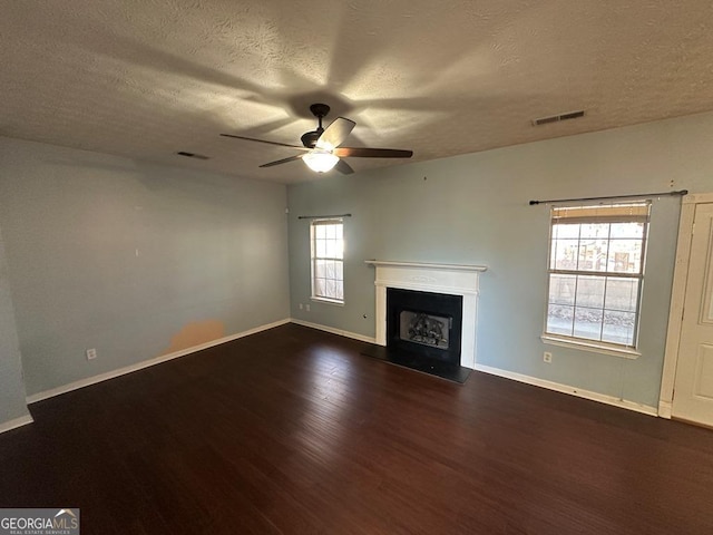 unfurnished living room with a textured ceiling, ceiling fan, and dark hardwood / wood-style floors