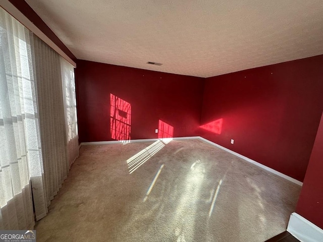 spare room with a textured ceiling and carpet