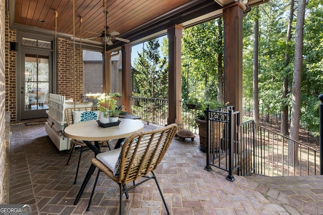 sunroom with a healthy amount of sunlight, ceiling fan, and wood ceiling