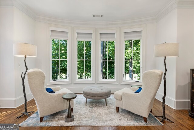 sitting room featuring ornamental molding and hardwood / wood-style flooring