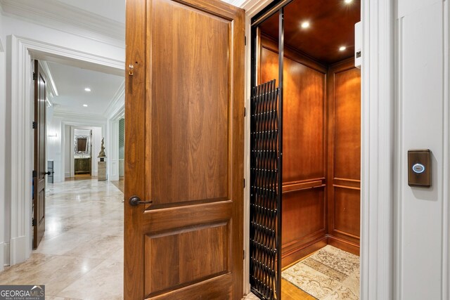 interior details featuring ornamental molding and elevator