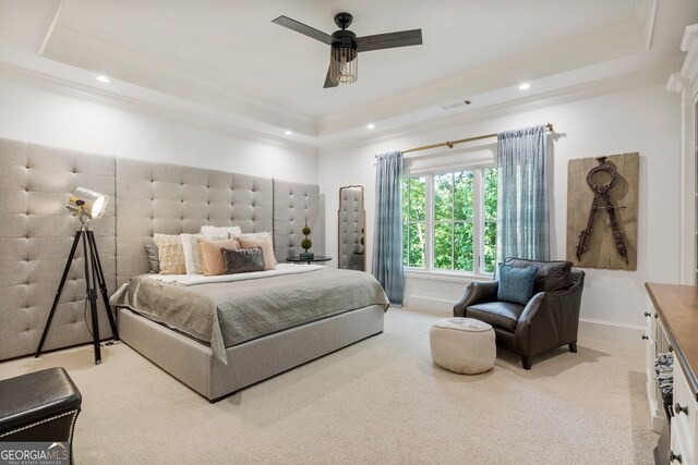 carpeted bedroom featuring a raised ceiling, ceiling fan, and crown molding