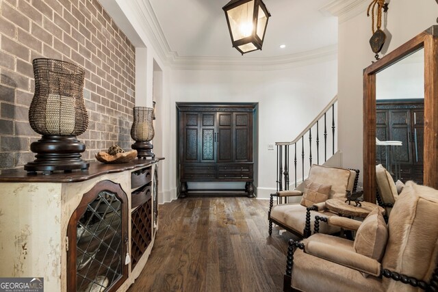 entrance foyer with ornamental molding and dark hardwood / wood-style floors