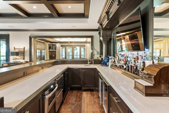 bar featuring a healthy amount of sunlight, crown molding, dark hardwood / wood-style flooring, and oven