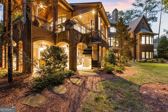 view of front of house with a balcony and a lawn