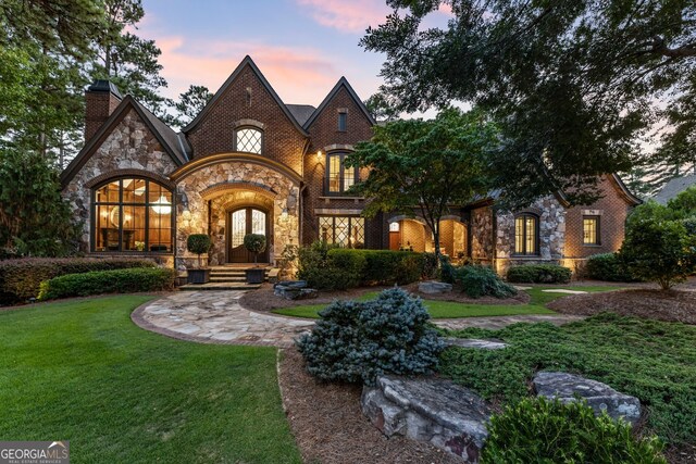 view of front of property with french doors and a yard