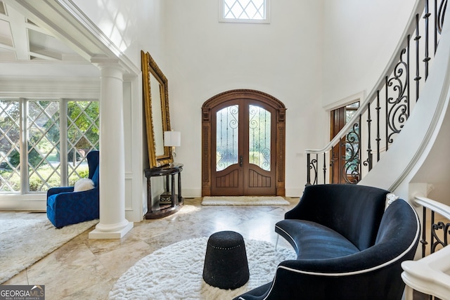 foyer featuring a wealth of natural light, french doors, and a towering ceiling