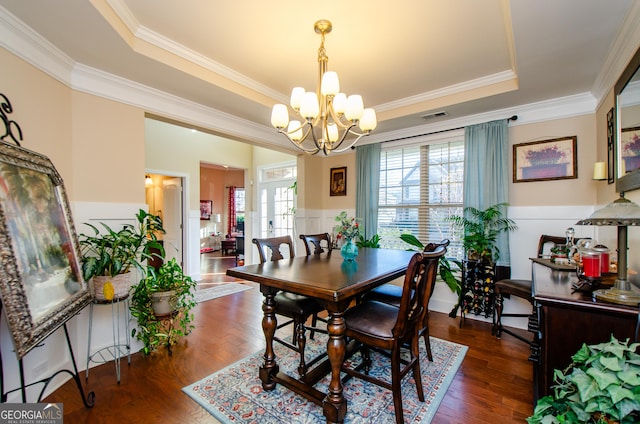 dining room featuring a raised ceiling, a chandelier, crown molding, and dark hardwood / wood-style floors