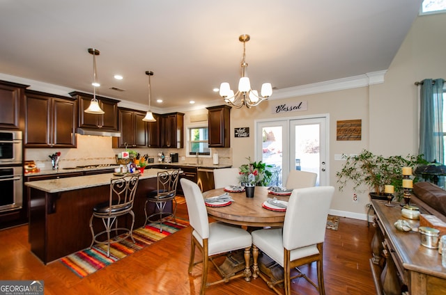 dining room featuring sink, ornamental molding, a chandelier, and dark hardwood / wood-style floors