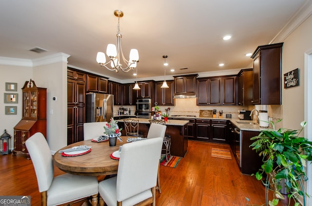 dining space with sink, an inviting chandelier, ornamental molding, and dark hardwood / wood-style floors