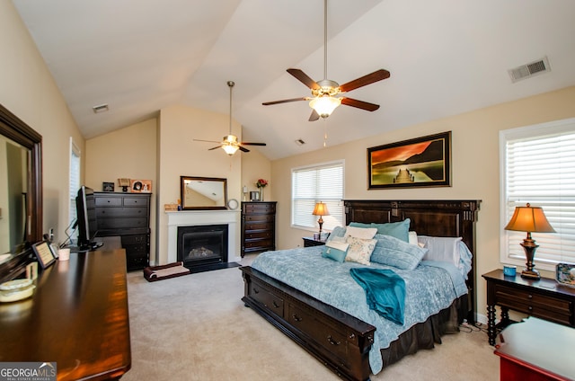 bedroom featuring vaulted ceiling, light colored carpet, and ceiling fan