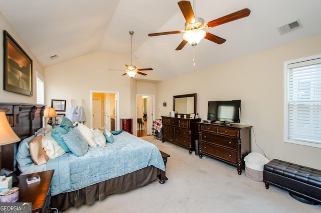 bedroom with lofted ceiling, light colored carpet, ceiling fan, and connected bathroom