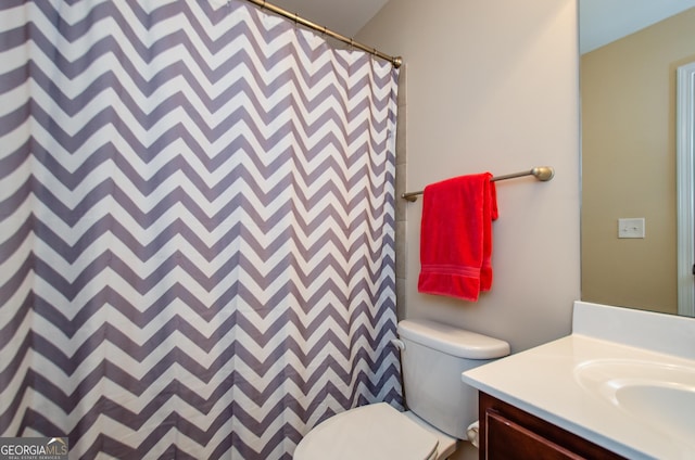 bathroom with toilet, a shower with shower curtain, and vanity