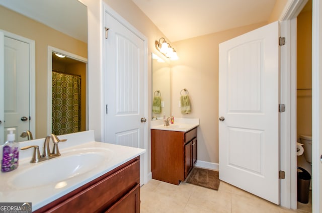 bathroom with tile patterned flooring, vanity, and toilet