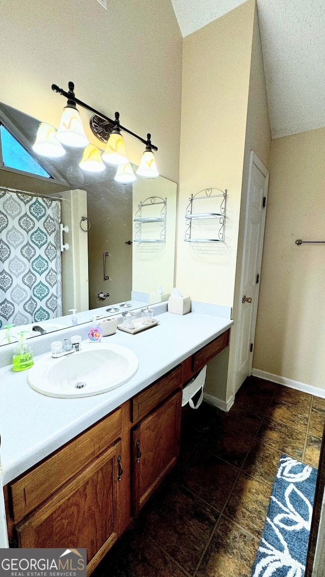 bathroom with lofted ceiling, a textured ceiling, and vanity