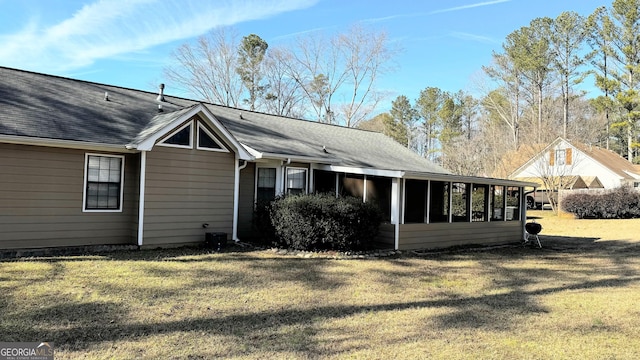 rear view of property featuring a yard and a sunroom