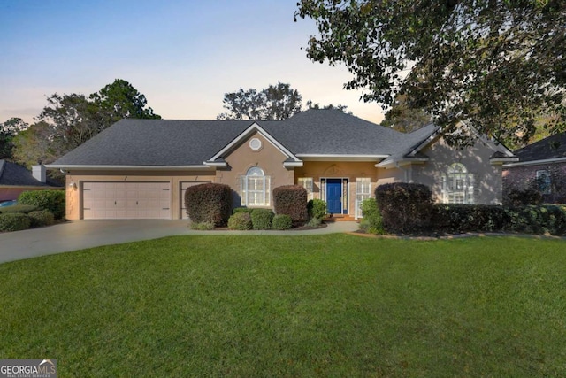 single story home featuring a lawn and a garage