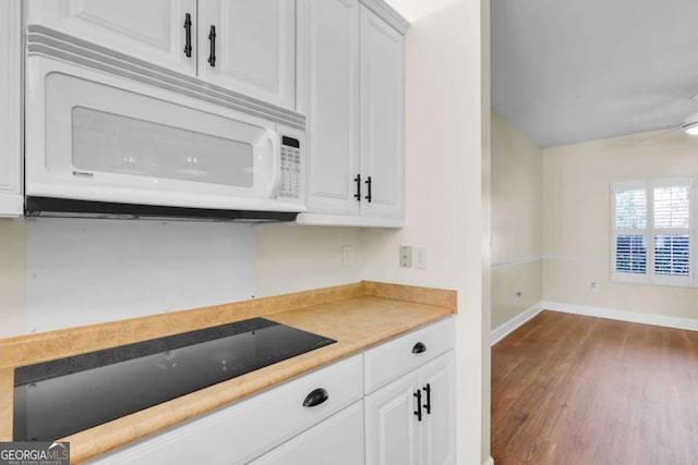 kitchen with white cabinets, ceiling fan, wood-type flooring, and black electric cooktop