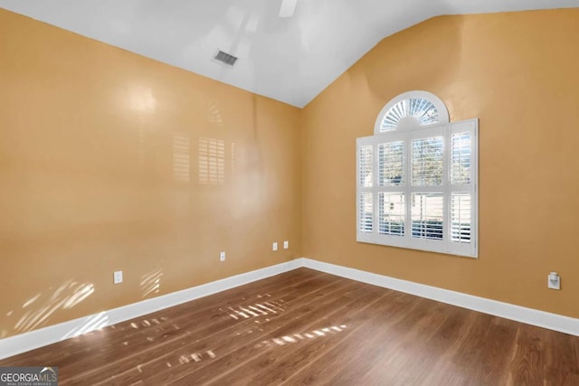 spare room featuring lofted ceiling and wood-type flooring