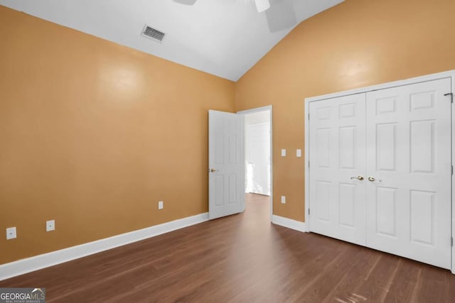 unfurnished bedroom featuring vaulted ceiling, ceiling fan, a closet, and dark hardwood / wood-style floors