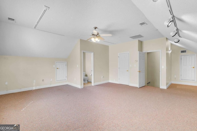 bonus room with vaulted ceiling, a textured ceiling, ceiling fan, and light carpet