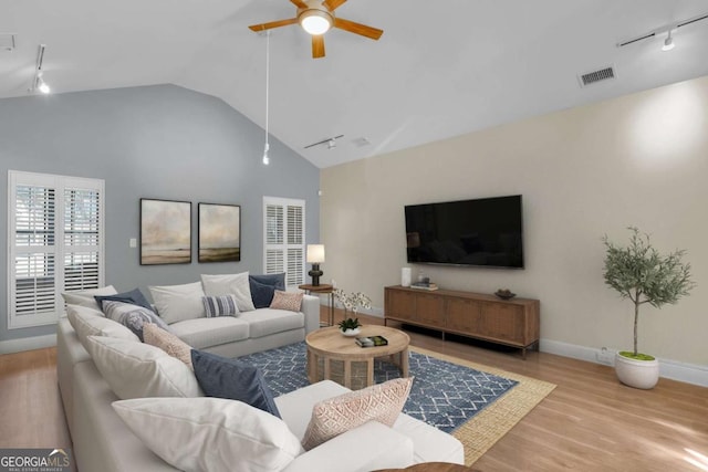 living room with light wood-type flooring, ceiling fan, vaulted ceiling, and track lighting