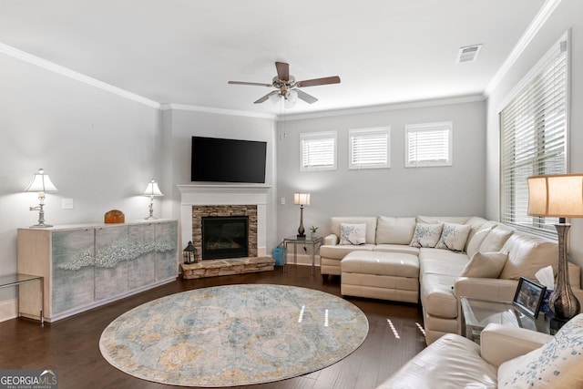 living room featuring a fireplace, dark wood-type flooring, ceiling fan, and a healthy amount of sunlight