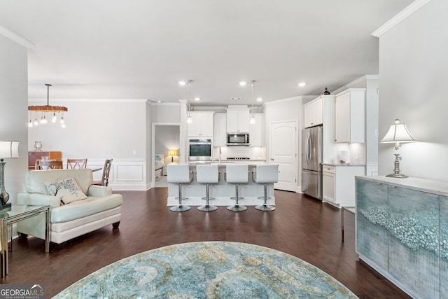 living room with crown molding, dark hardwood / wood-style flooring, and sink