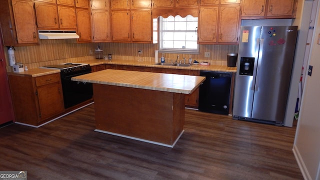 kitchen featuring sink, a kitchen island, dark hardwood / wood-style flooring, and black appliances