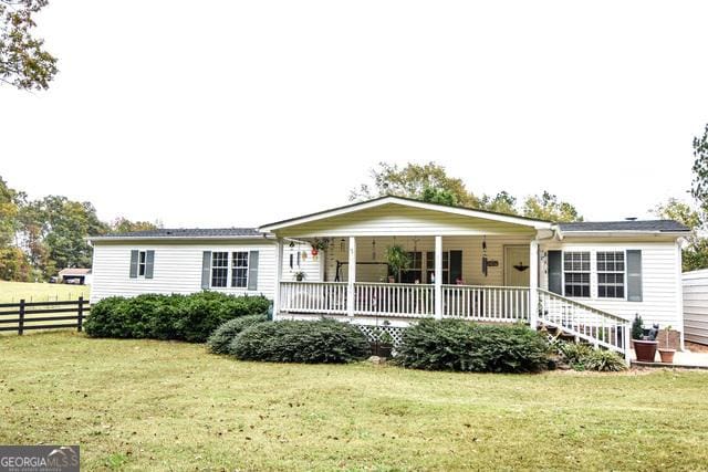 ranch-style home with a front yard and covered porch