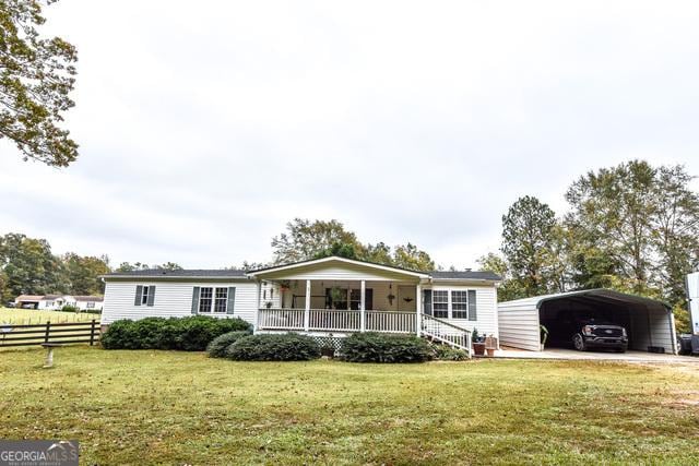 view of front facade with covered porch, a carport, and a front lawn