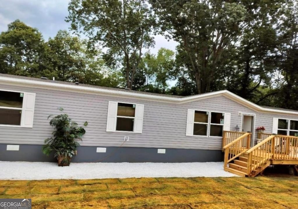 view of front of home with a front yard and a deck