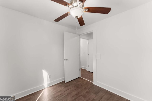 unfurnished room with dark hardwood / wood-style flooring and ceiling fan