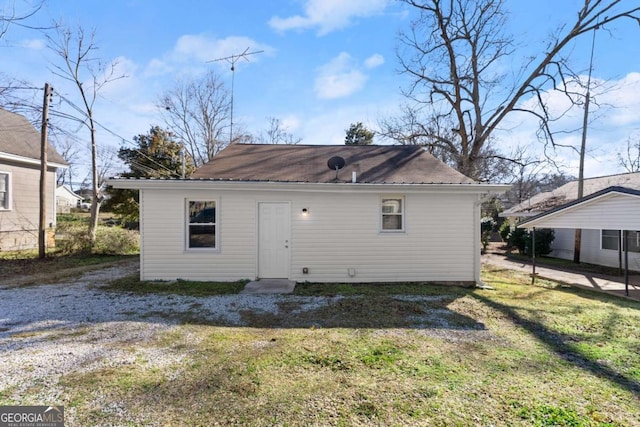 rear view of house featuring a yard